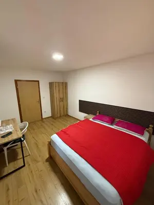 a bedroom with a large bed with a red blanket at Motel Napoleon in Velika Kladuša