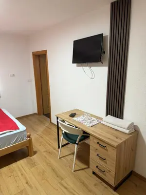 a room with a desk and a bed and a television at Motel Napoleon in Velika Kladuša