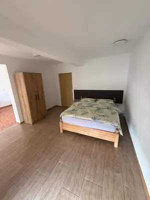 a bedroom with a bed and wooden floors at Motel Napoleon in Velika Kladuša