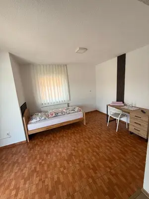a room with a bed and a desk in it at Motel Napoleon in Velika Kladuša