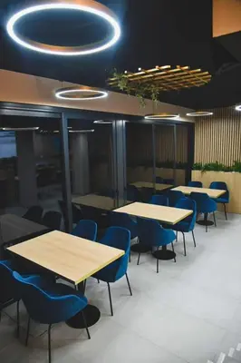 a dining room with tables and blue chairs at Motel Napoleon in Velika Kladuša