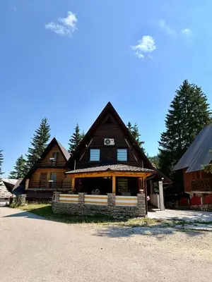 a large wooden house with a porch in front at Endzi V&S in Šišava
