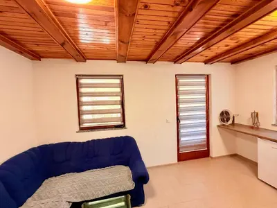 a living room with a blue couch and two windows at Endzi V&S in Šišava