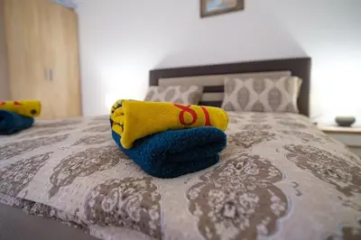 a bed with blue and yellow pillows on it at Natural paradise Sake in Visoko