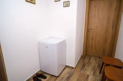 a small white refrigerator in a room with a door at Natural paradise Sake in Visoko