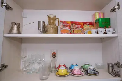 a shelf with wine glasses and dishes on it at Natural paradise Sake in Visoko