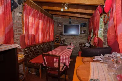 a restaurant with red curtains and a table and chairs at Natural paradise Sake in Visoko