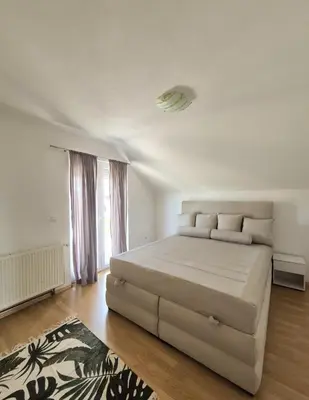 a white bedroom with a large white bed and a rug at Wildlight in Bihać