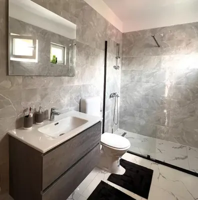 a bathroom with a sink and a toilet and a shower at Apartman 369 in Jajce