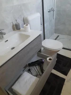 a white bathroom with a sink and a toilet at Apartman 369 in Jajce
