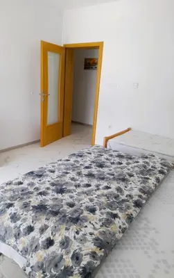 a bedroom with a bed with a blue and white comforter at Apartman 369 in Jajce