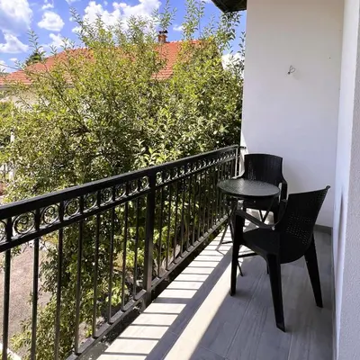a black table and chair on a balcony at Apartman 369 in Jajce
