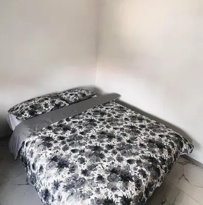 a bed with a black and white comforter and pillow at Apartman 369 in Jajce