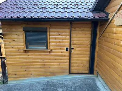 a wooden shed with a door and a window at Djedovo Ognjiste,prenociste in Modriča