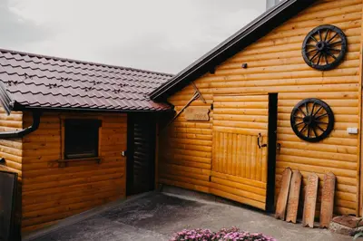 a wooden cabin with a wooden door and windows at Djedovo Ognjiste,prenociste in Modriča