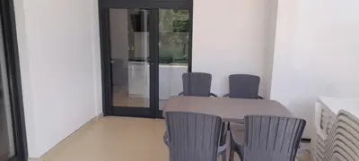 a table and chairs in a room with a glass door at Apartmani na Uni Šarac