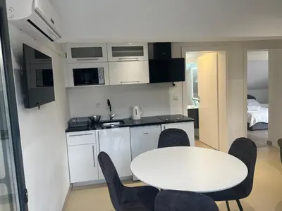 a small kitchen with a white table and chairs at Apartmani na Uni Šarac
