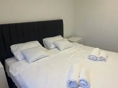 a white bed with towels on top of it at Apartmani na Uni Šarac