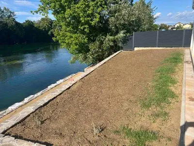 a retaining wall next to a river at Apartmani na Uni Šarac