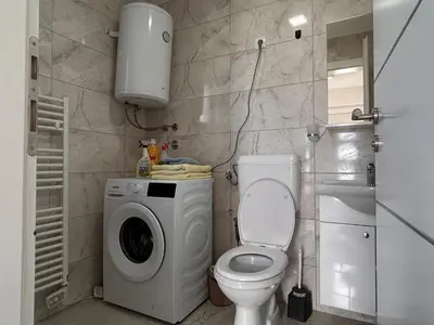 a bathroom with a washing machine and a toilet at Vikendica Nuhanović - Vlašić in Vlasic