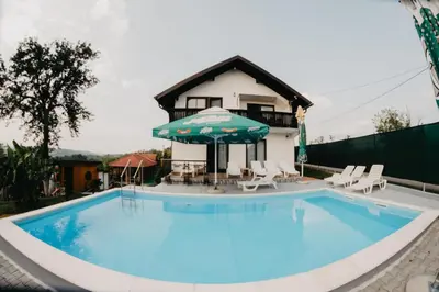a swimming pool in front of a house at Djedovo ognjište 2
