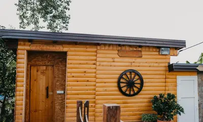 a wooden cabin with a door and a wheel at Djedovo ognjište 2