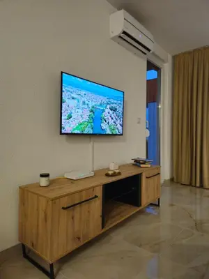 a living room with a flat screen tv on a wall at Apartman devet rijeka in Sanski most