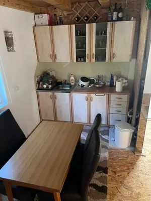 a kitchen with wooden cabinets and a wooden table at Oaza mira -Trnovo in Ivišovo Greblje