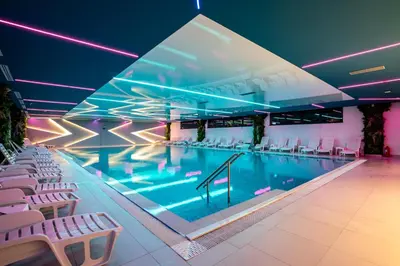 a large swimming pool with white chairs around it at Hotel President & SPA Maglaj in Maglaj