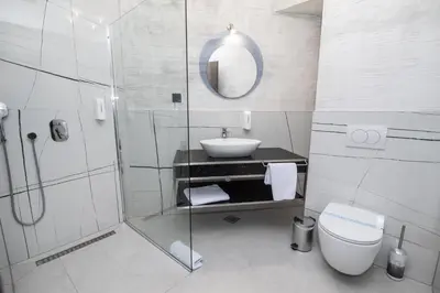 a white bathroom with a sink and a toilet at Hotel President & SPA Maglaj in Maglaj
