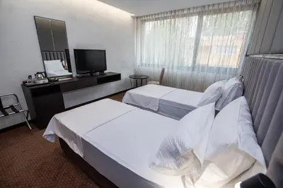 a hotel room with two beds and a television at Hotel President & SPA Maglaj in Maglaj