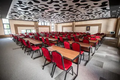 a room with wooden tables and red chairs at Hotel President & SPA Maglaj in Maglaj