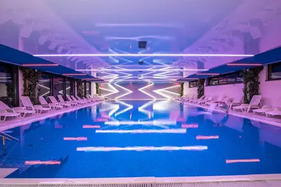 a large swimming pool with chairs in a building at Hotel President & SPA Maglaj in Maglaj