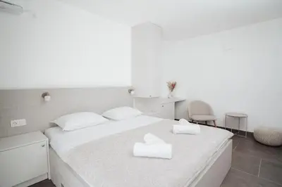 a bedroom with a bed with two white towels on it at Villa Apartments Blanco - Near Airport Banja Luka in Laktaši