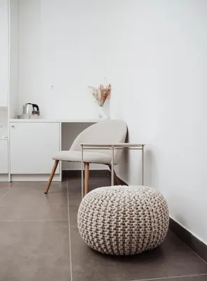 a chair and a ottoman in a room at Villa Apartments Blanco - Near Airport Banja Luka in Laktaši