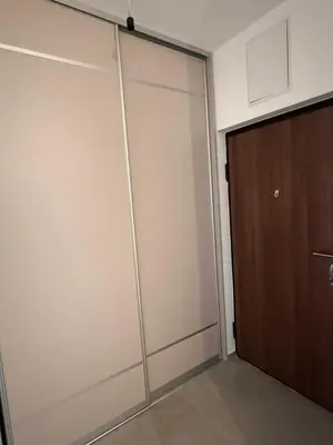 a sliding glass door in a room with a brown door at Panorama apartman in Banja Luka