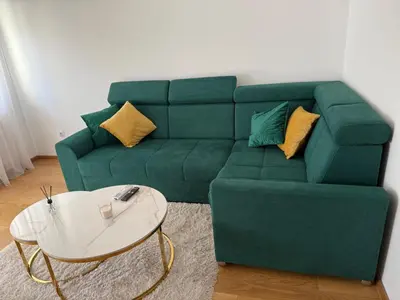 a green couch and a coffee table in a living room at Panorama apartman in Banja Luka