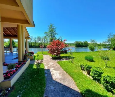 a house with a walkway next to a river at Villa Ela in Prijedor