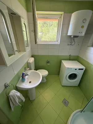 a green bathroom with a sink and a toilet at Villa Ela in Prijedor