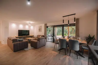 a living room with a table and a dining room at Villa Verde House by the River Sturba in Livno