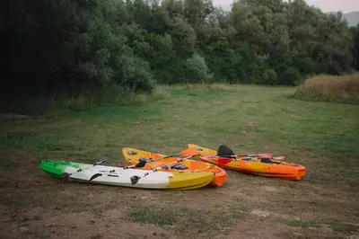 three kayaks are sitting on the grass in a field at Villa Verde House by the River Sturba in Livno