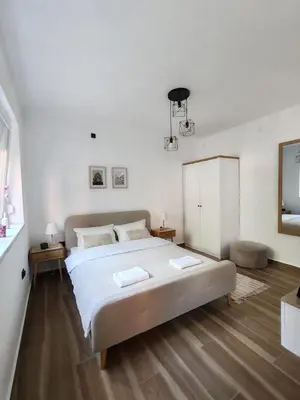 a white bedroom with a large bed and a window at Studio 23 in Banja Luka