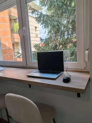 a laptop computer sitting on a desk next to a window at Studio 23 in Banja Luka