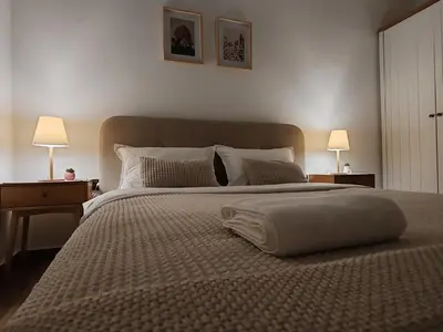 a bedroom with a large bed with two lamps at Studio 23 in Banja Luka