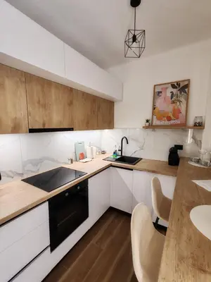 a kitchen with white cabinets and a sink and a table at Studio 23 in Banja Luka