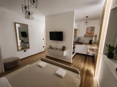 a living room with a couch and a desk with a television at Studio 23 in Banja Luka