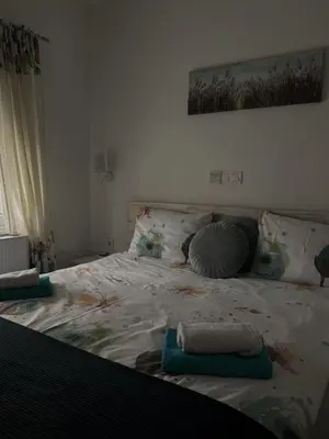 a bedroom with a large bed with blankets and pillows at Motel Ječmište in Tuzla