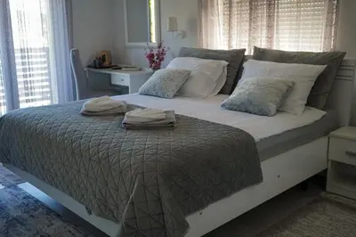 a bedroom with a large bed with two towels on it at Motel Ječmište in Tuzla