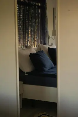 a bed with pillows on it with a window at Motel Ječmište in Tuzla