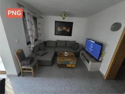 a living room with a couch and a tv at Stan na Dan Cazin in Ivišovo Greblje